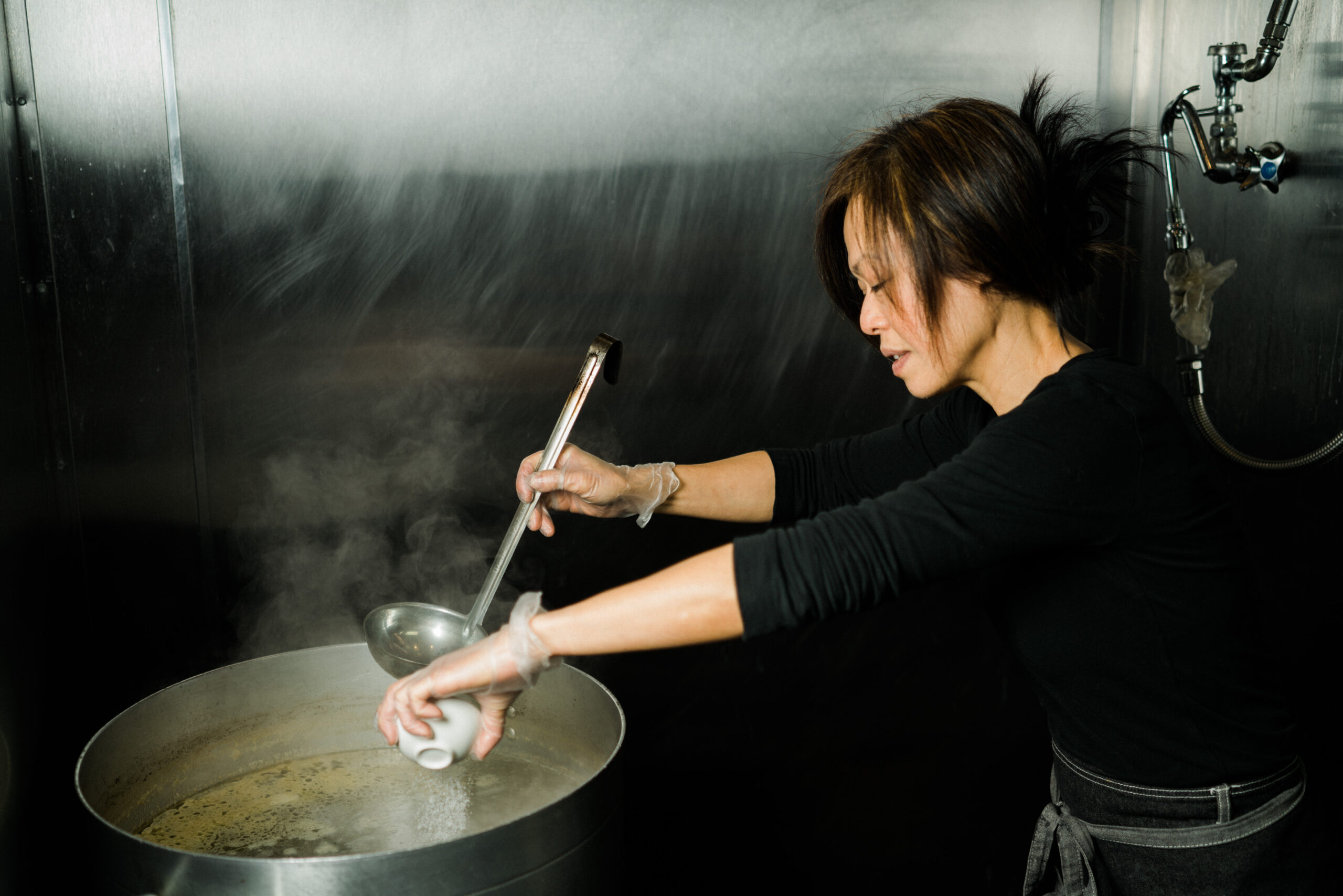 Sa seasoning a large steaming pot in the kitchen